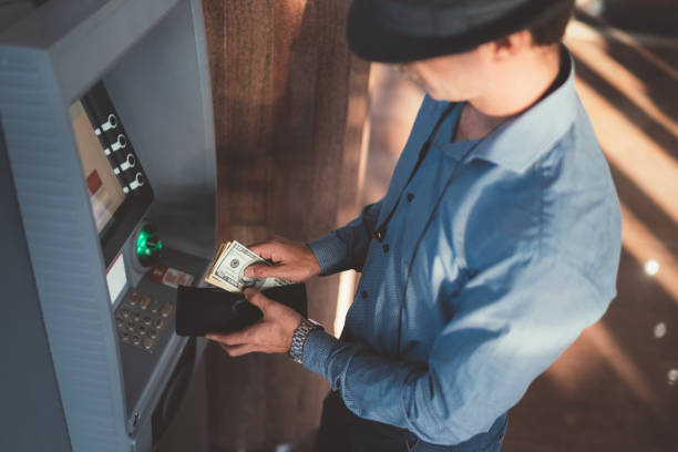 istock Businessman withdrawing money from cash machine 1056331228