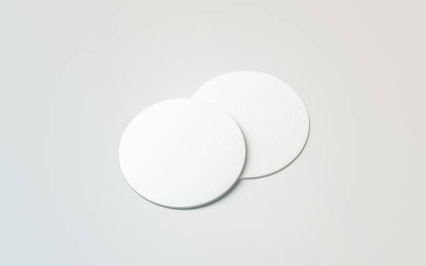 Blank white two beer coasters mockup set, isolated Blank white two beer coasters mockup set, isolated, 3d rendering. Blank round rug for beverage mock up. Empty bottle coaster lying. Circular can mat design. cork material stock pictures, royalty-free photos & images