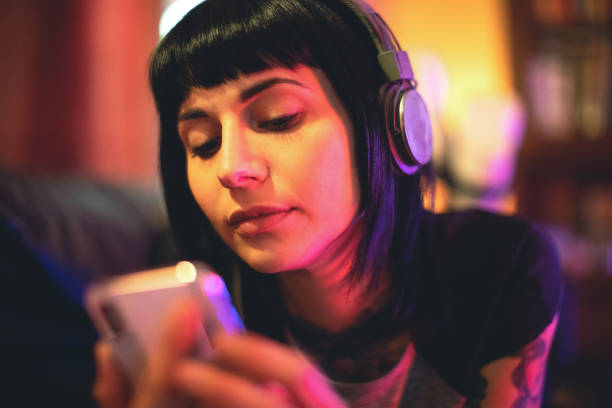 istock Young woman relaxing with smartphone on sofa 1056334180