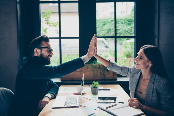 istock Two cheerful modern professional stylish classic elegant people, partners, leaders, beautiful adorable lady, bearded man celebrating tender winning at industrial workplace, station 1056342098