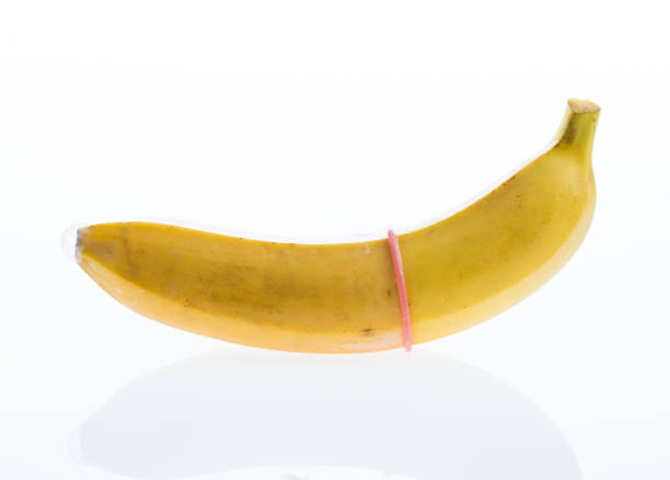 banan z prezerwatywą wyizolowany na białym tle - single object sensuality education isolated zdjęcia i obrazy z banku zdjęć