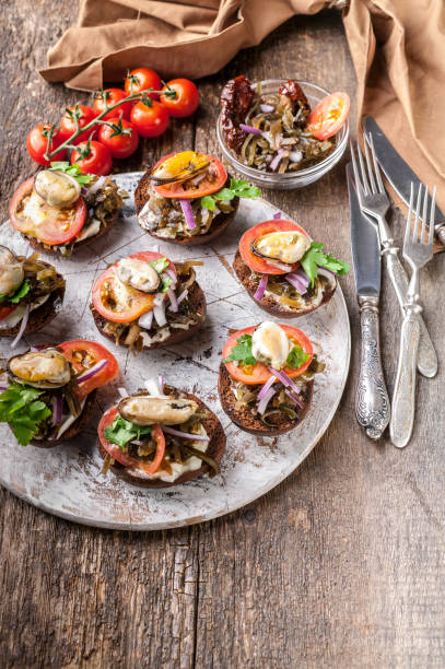istock Canapes with cream cheese and tomatoes on a round chopping board. Mediterranean Kitchen. Vertical shot 1056342748