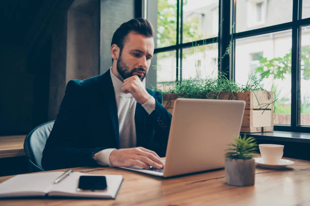 istock Minded modern professional stylish classic bearded man, leader in jacket typing online presentation, document at industrial workplace, workstation 1056344642