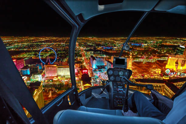 Scenic flight on Las Vegas skyline Helicopter interior on Las Vegas buildings and skyscrapers of downtown with illuminated casino hotels at night. Scenic flight above Vegas skyline by night in the Nevada United States of America. helicopter stock pictures, royalty-free photos & images