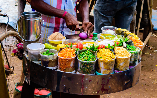 Seller selling on of the famous Indian and Bengali street food made by puffed rice and various ingredients called Jhal Muri