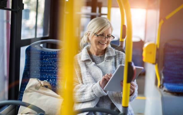 senior passenger using digital tablet - transportation bus mode of transport public transportation imagens e fotografias de stock