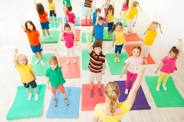 istock Warming-up during gymnastic lesson for kids in gym 1056357988