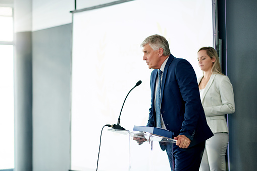 Shot of a mature businessman giving a speech at a conference