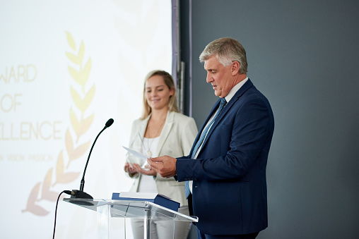 Shot of a mature businessman delivering a speech during an awards giving ceremony at a conference