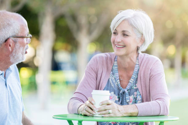 istock Senior couple enjoy discussion at sidewalk cafe table 1056360154