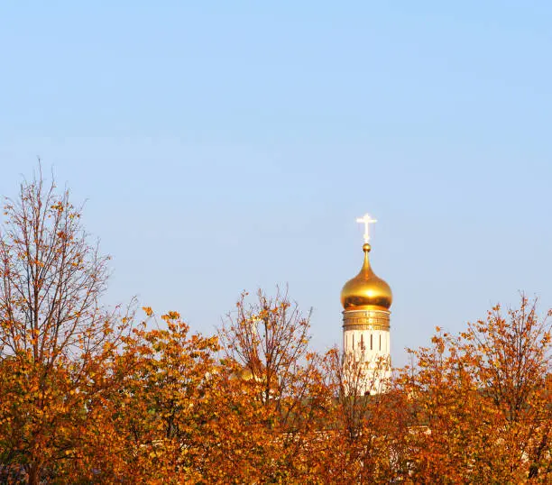 Autumn, yellow foliage, blue sky, Ivan the Great Bell Tower, church-bell tower as part of the Moscow Kremlin Cathedral Square architectural ensemble, Russia