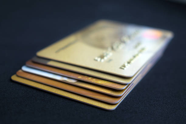 istock Stack of gold credit cards on dark background, close up view with selective focus. Different VIP credit cards, background with copy space. Payment gold, Paying, Buying 1056367952