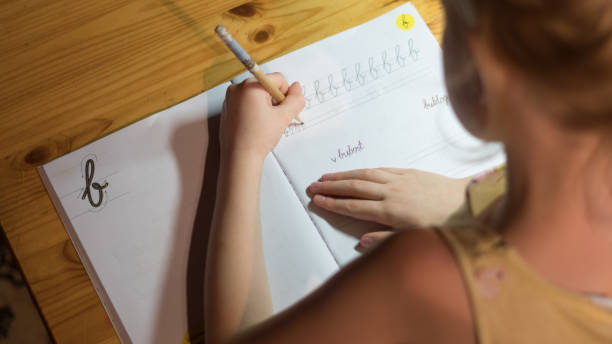 istock A six years old girl is practicing writing in a notebook. 1056369896
