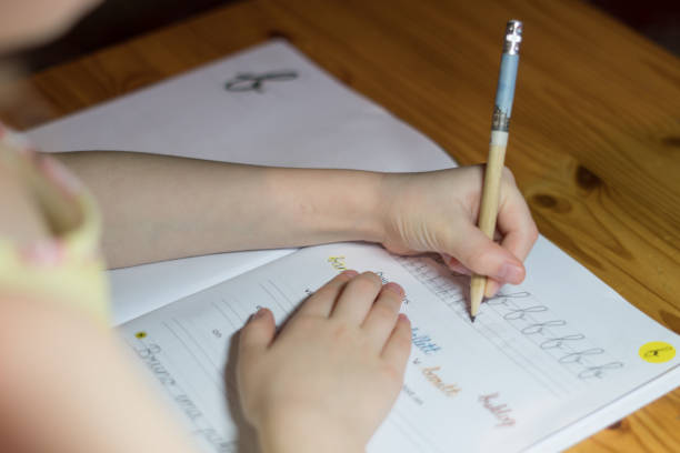 istock A six year old girl is practicing writing in a notebook. 1056370294