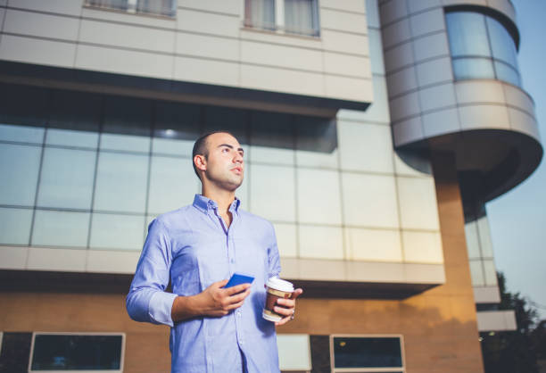 istock Man in front of building with phone 1056371998