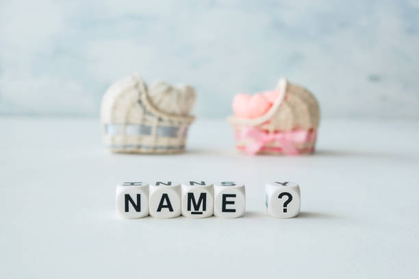 concetto di scelta del nome del bambino. culle decorative in paglia rosa e blu con cuori di filo e nome di testo? su sfondo chiaro - identity foto e immagini stock