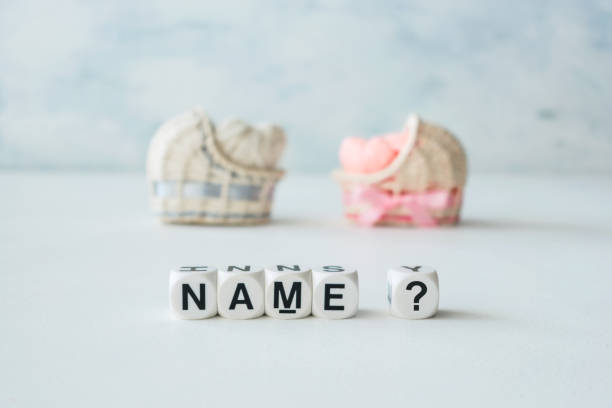 Concept of choosing baby name. Pink and blue decorative straw cradles with thread hearts and text name? on light background Concept of choosing baby name. Pink and blue decorative straw cradles with thread hearts and text name? on light background identity stock pictures, royalty-free photos & images