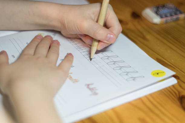 istock A six year old girl is practicing writing in a notebook. 1056372918