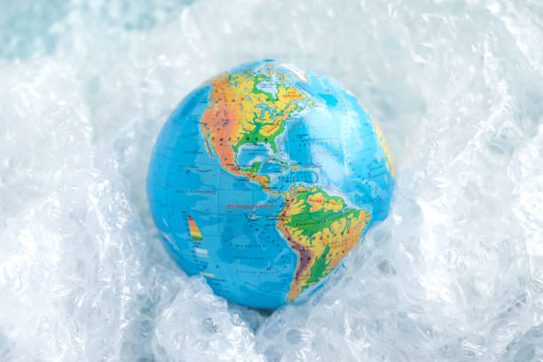 istock Physical globe, Earth in plastic wrap in carton box on blue background with copy space Recyclable packaging Ecology problem of environmental pollution planet by plastic Earth Day World Environment Day 1056373774