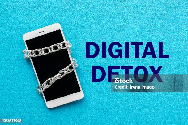 White Smartphone With Metal Chain On Blue Background Digital Detox Dependency On Tech No Gadget And Devices Concept Stock Photo - Download Image Now