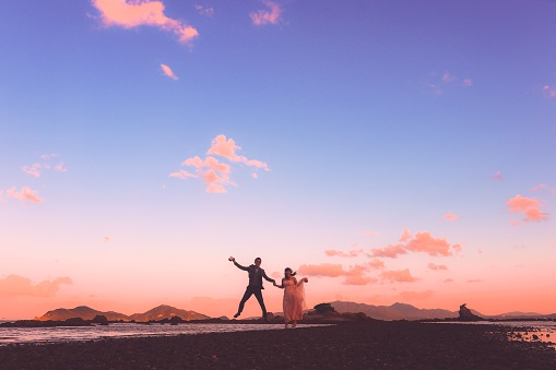 Two Japanese married at the dramatic location and sunset scene.