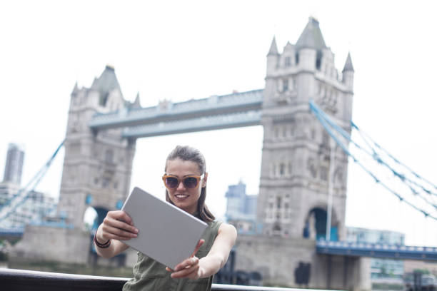 istock Woman taking selfie with tablet on Tower bridge 1056380936