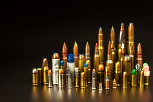 Diferentes tipos de municiones sobre un fondo negro. Venta de armas y municiones. El derecho a sostener un arma. photo