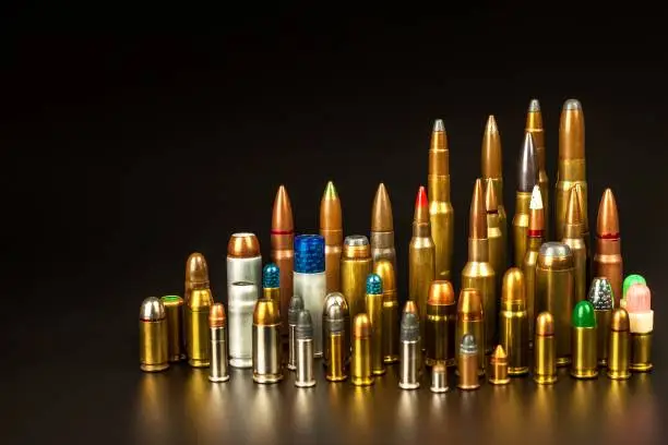 Photo of Different types of ammunition on a black background. Sale of weapons and ammunition. The right to hold a gun.