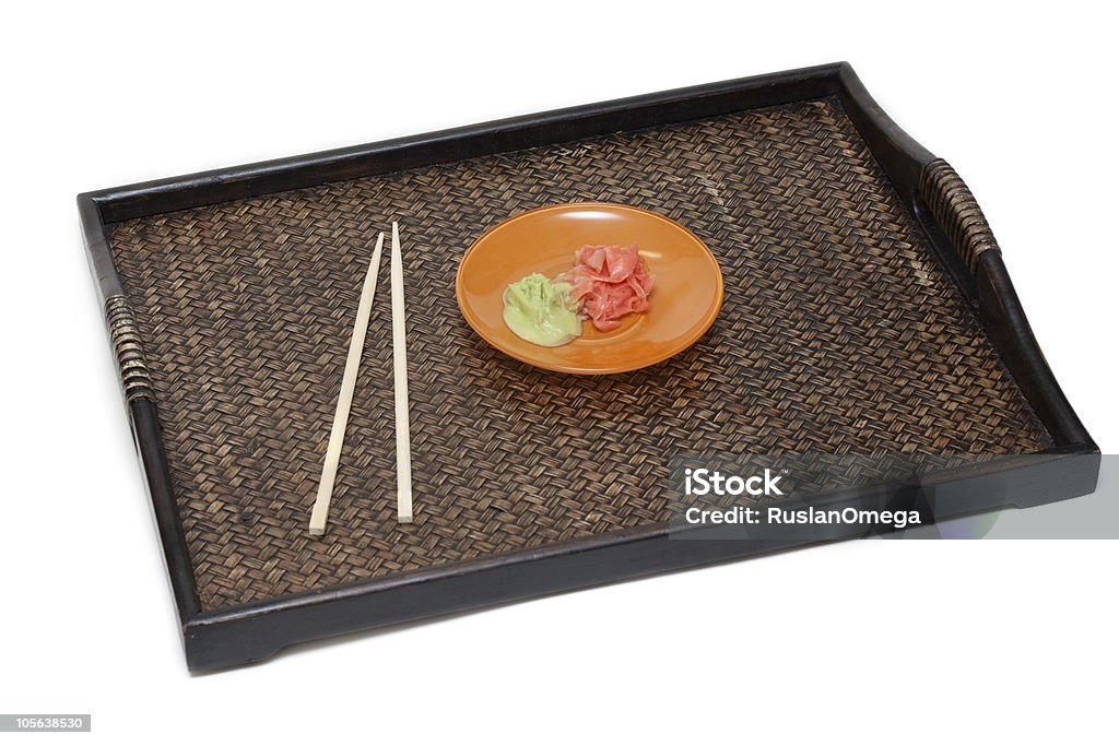 Orange saucer with ginger Orange saucer with ginger and sharp seasoning on bamboo tray near by chopstick insulated on white background Asia Stock Photo