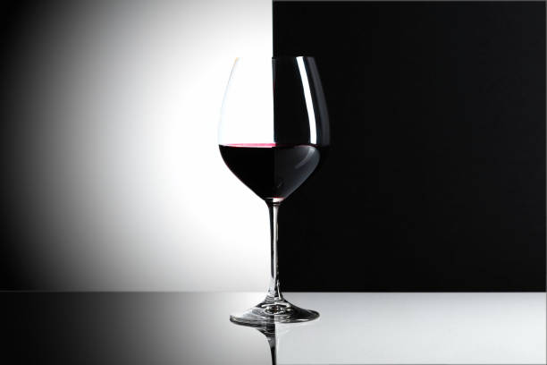 Glass of red wine on a reflexive background, copy space for your text.