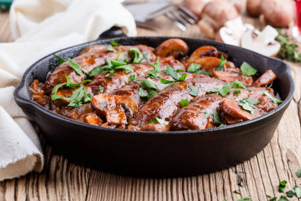 istock Sausages with onion and mushrooms gravy 1056392700