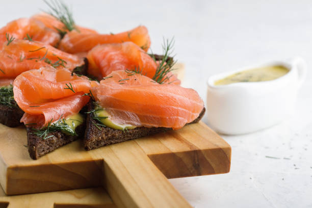 gravad lax caseiro, salmão com molho de mostarda e aneto em pão de centeio torrado - gravlax - fotografias e filmes do acervo