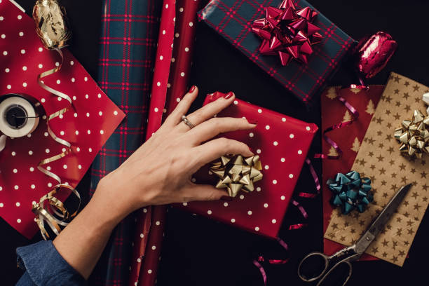 frau weihnachtsgeschenke verpacken präsentiert foto von oben overhead - einwickelpapier stock-fotos und bilder