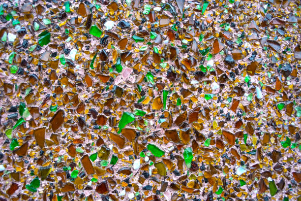 texture of concrete wall covered with shards of multicolored bottle glass.