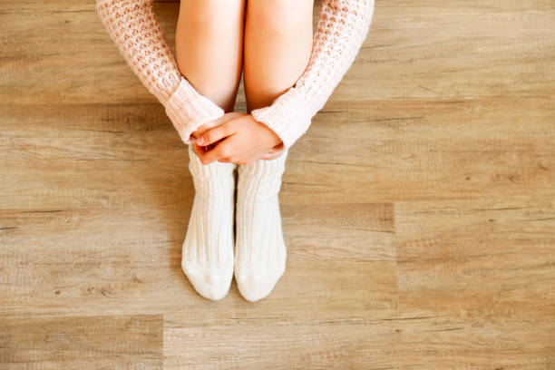 młoda kobieta siedząca w domu. zbliżenie kobiecych nóg czyste ogolone o gładkiej skórze. - cold feet zdjęcia i obrazy z banku zdjęć