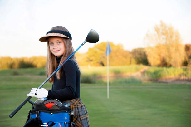 A Happy Young Girl at the Golf Course A beautiful young girl playing golf at her local golf course. junior level stock pictures, royalty-free photos & images