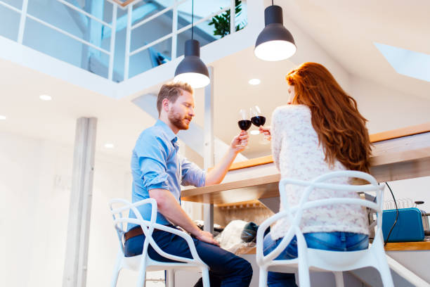 istock Beautiful couple drinking wine in living room 1056410464