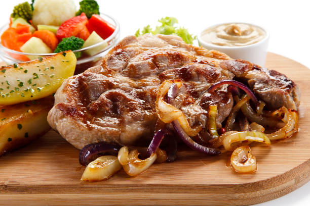 istock Grilled beefsteak, baked potatoes and vegetables on cutting board 1056413482
