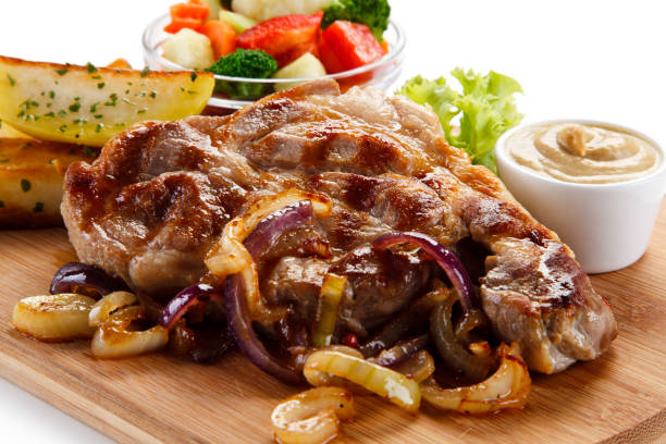 istock Grilled beefsteak, baked potatoes and vegetables on cutting board 1056414024