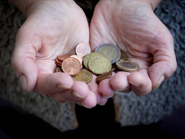 istock Retired with coins in hand. Problem of poverty. 1056415436