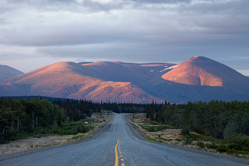 Alaska Highway and alpenglow smothered mountain