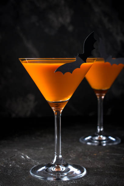 istock Orange pumpkin  martini Halloween drink for party over black background with copy space 1056420376