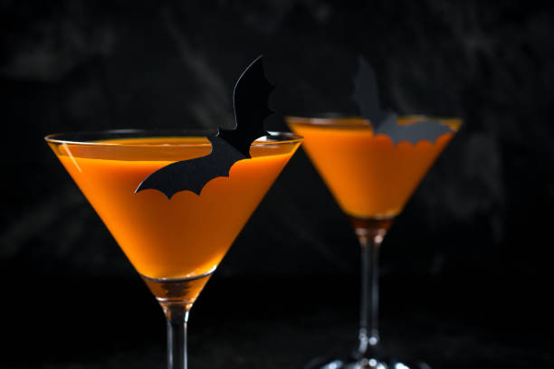 istock Orange pumpkin  martini Halloween drink for party over black background with copy space 1056420390