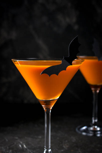istock Orange pumpkin  martini Halloween drink for party over black background with copy space 1056420416
