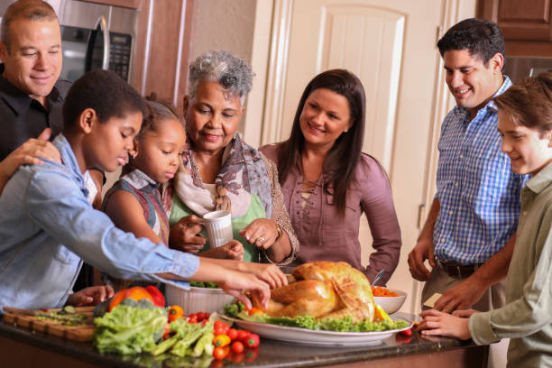 istock Diverse family in home kitchen cooking Thanksgiving dinner. 1056423320