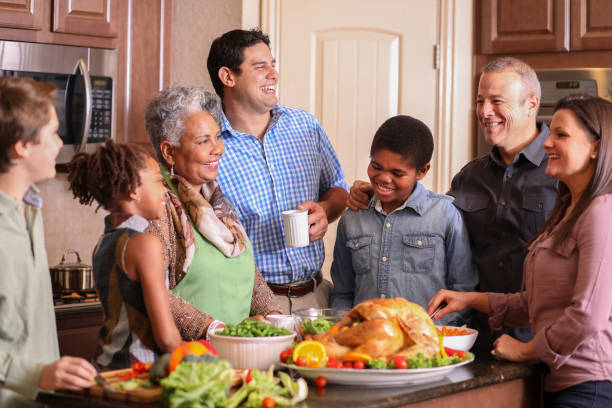 istock Diverse family in home kitchen cooking Thanksgiving dinner. 1056423378