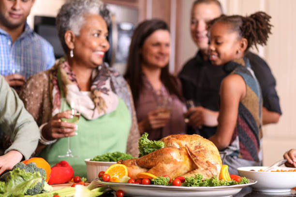 istock Diverse family in home kitchen cooking Thanksgiving dinner. 1056423690