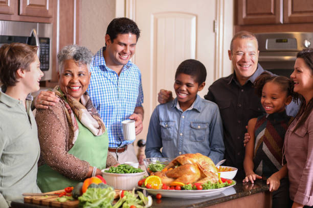 istock Diverse family in home kitchen cooking Thanksgiving dinner. 1056424192