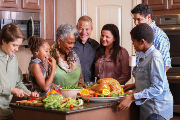 istock Diverse family in home kitchen cooking Thanksgiving dinner. 1056424444