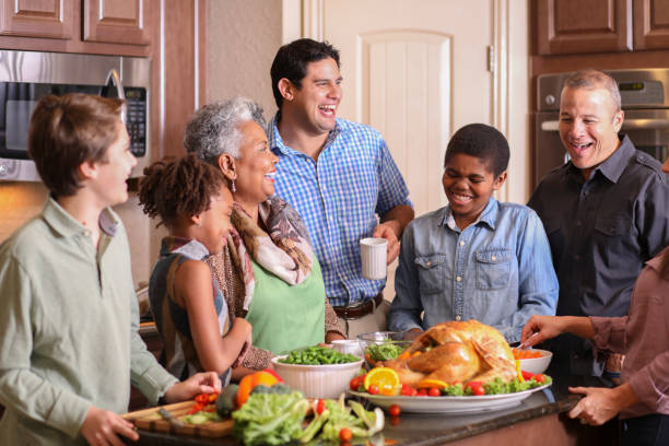 istock Diverse family in home kitchen cooking Thanksgiving dinner. 1056424596